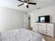 This bedroom features neutral walls, a ceiling fan and a dresser with a television at 9525 Sw 200 Ct, Dunnellon, FL 34431