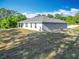 Side view of a one-story home, featuring a white exterior and a grassy backyard at 9525 Sw 200 Ct, Dunnellon, FL 34431
