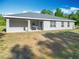 View of home's rear exterior with covered patio and well-maintained landscaping at 9525 Sw 200 Ct, Dunnellon, FL 34431