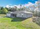 Side angle showcasing the well-maintained yard, complemented by verdant landscaping and trees at 9525 Sw 200 Ct, Dunnellon, FL 34431