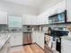 The bright kitchen features stainless steel appliances and stylish backsplash and countertop at 9525 Sw 200 Ct, Dunnellon, FL 34431