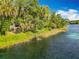 Picturesque waterfront view showcases a tranquil river surrounded by lush greenery and a charming gazebo at 9525 Sw 200 Ct, Dunnellon, FL 34431