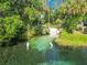 Stunning waterfront featuring clear turquoise water, lush greenery, and recreational activities at 9525 Sw 200 Ct, Dunnellon, FL 34431