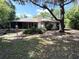 View of the home's screened in back porch and backyard surrounded by natural trees at 9711 Sw 196Th Cir, Dunnellon, FL 34432