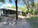 View of the home's screened in back porch with a spacious backyard surrounded by trees at 9711 Sw 196Th Cir, Dunnellon, FL 34432
