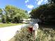 Exterior shot of the home with beautiful landscaping and a blue sky backdrop at 9711 Sw 196Th Cir, Dunnellon, FL 34432