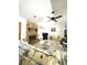 Bright living room with stone fireplace, floral patterned seating and ceiling fan at 9711 Sw 196Th Cir, Dunnellon, FL 34432