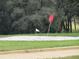 Close up view of sand trap with green grass, red and white flags visible at 9711 Sw 196Th Cir, Dunnellon, FL 34432