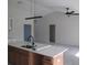 Open kitchen featuring a center island, modern lighting, and white cabinets at 10409 Sw 45 St, Ocala, FL 34481