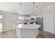 Clean, bright kitchen boasts white cabinetry, stainless steel appliances, a center island, and modern pendant lighting at 10426 Sw 133Rd Ave, Dunnellon, FL 34434