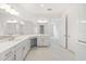 Bathroom featuring double sinks, white cabinets, and neutral tile flooring at 10530 Sw 98Th Pl, Ocala, FL 34481