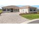 Paver driveway leading to an attached two car garage; neutral paint and blue shutters make this home attractive at 10530 Sw 98Th Pl, Ocala, FL 34481