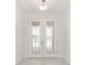 Bright, welcoming foyer featuring a white front door with glass inserts and light-colored flooring at 10530 Sw 98Th Pl, Ocala, FL 34481