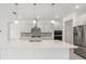 Stylish kitchen island with pendant lighting, stainless steel appliances and white cabinetry at 10530 Sw 98Th Pl, Ocala, FL 34481