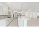Modern kitchen featuring a large island, stainless steel appliances, and gray backsplash at 10530 Sw 98Th Pl, Ocala, FL 34481