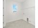 Bright laundry room with tile flooring, window, and shelving for efficient organization at 10530 Sw 98Th Pl, Ocala, FL 34481