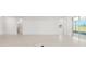Spacious living room with light-colored floors, neutral walls, and large windows offering backyard view at 10530 Sw 98Th Pl, Ocala, FL 34481