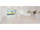 Bright, open-concept living area with sleek tile flooring, neutral paint, and seamless kitchen integration at 10530 Sw 98Th Pl, Ocala, FL 34481