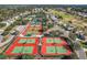 Aerial view of community tennis courts. Pristine courts surrounded by mature trees and landscaping at 12165 Se 91St Ave, Summerfield, FL 34491