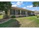 This home features a screened-in porch surrounded by lush landscaping and a neatly manicured lawn at 12165 Se 91St Ave, Summerfield, FL 34491