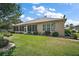 Well-maintained lawn and mature trees frame a screened-in porch, creating an inviting outdoor space at 12165 Se 91St Ave, Summerfield, FL 34491