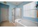 Bright bathroom showcasing a bathtub, glass enclosed shower, and light blue accents at 12165 Se 91St Ave, Summerfield, FL 34491
