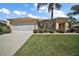 Charming home with manicured lawn, lush landscaping, and a two-car garage in a sunny neighborhood at 12165 Se 91St Ave, Summerfield, FL 34491