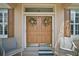 Elegant double front doors with decorative wreaths, sidelights, and cozy chairs on the porch at 12165 Se 91St Ave, Summerfield, FL 34491
