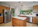 Spacious kitchen featuring stainless steel appliances, a large island, and white countertops for meal preparation at 12165 Se 91St Ave, Summerfield, FL 34491
