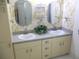 Bathroom featuring double sinks, ample storage space, and decorative wallpaper at 13816 Sw 112Th Ter, Dunnellon, FL 34432