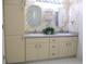 Bathroom featuring double sinks, ample storage space, and decorative wallpaper at 13816 Sw 112Th Ter, Dunnellon, FL 34432