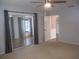 Bright bedroom featuring sliding glass doors, ceiling fan, and neutral carpeting at 13816 Sw 112Th Ter, Dunnellon, FL 34432