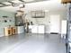Spacious garage interior with epoxy flooring, featuring storage shelving, a workbench, and laundry appliances at 13816 Sw 112Th Ter, Dunnellon, FL 34432