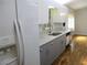 Modern kitchen features white upper and gray lower cabinets, stainless steel appliances, and wood-look floors at 13816 Sw 112Th Ter, Dunnellon, FL 34432