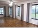 Bright living room showcasing hardwood floors and large windows with modern curtains at 13816 Sw 112Th Ter, Dunnellon, FL 34432