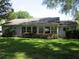 Expansive back exterior featuring a sunroom and manicured hedges on a well-maintained lawn at 14272 Sw 112Th Cir, Dunnellon, FL 34432