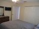 Bedroom showcasing a mounted TV, dresser, and a large bed with a patterned comforter at 14272 Sw 112Th Cir, Dunnellon, FL 34432