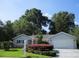 Charming single-story home with well-manicured lawn and mature trees under a clear blue sky at 14272 Sw 112Th Cir, Dunnellon, FL 34432