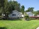 Well-manicured front lawn showcases the home's curb appeal with lush landscaping and a flagpole at 14272 Sw 112Th Cir, Dunnellon, FL 34432
