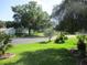 Well-maintained front yard with lush green lawn, palm trees, and charming neighborhood street at 14272 Sw 112Th Cir, Dunnellon, FL 34432