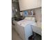 Laundry room area with a washing machine, dryer, utility sink, and overhead cabinets at 14272 Sw 112Th Cir, Dunnellon, FL 34432