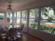 Bright sunroom with views of the landscaped backyard, ceiling fan, and hardwood floors at 14272 Sw 112Th Cir, Dunnellon, FL 34432