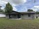 View of the rear exterior of the home, featuring a covered patio and a spacious backyard at 15036 Sw 35Th Cir, Ocala, FL 34473