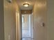 Neutral-toned hallway with multiple doors and a view into a carpeted room at 15036 Sw 35Th Cir, Ocala, FL 34473