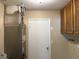 Functional utility room featuring cabinets, door to outside, and essential home systems at 15036 Sw 35Th Cir, Ocala, FL 34473