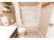 Cozy bathroom featuring a tiled bathtub and shower, soft rug, and neutral color palette at 1509 Ne 50Th Ter, Ocala, FL 34470
