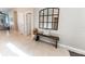 Open entryway with tile flooring, a dark wood bench, and a decorative mirror accenting the neutral-toned walls at 1509 Ne 50Th Ter, Ocala, FL 34470