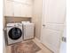 Functional laundry room with washer, dryer, cabinets, and bright lighting at 1509 Ne 50Th Ter, Ocala, FL 34470