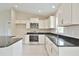 Close up on bright kitchen featuring stainless steel appliances and black countertops at 16219 Sw 48Th Cir, Ocala, FL 34473