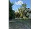 View of the backyard with lawn, mature trees and an American flag at 20386 Sw 95Th St, Dunnellon, FL 34431